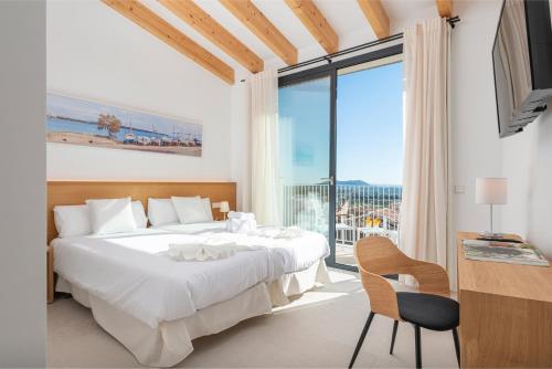 a bedroom with a large bed and a large window at Placeta Vella Turismo de Interior in Caimari