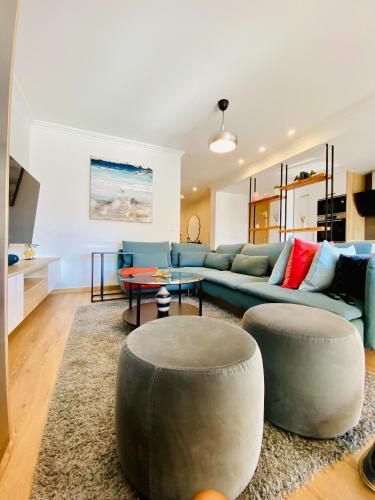 a living room with a blue couch and a table at Lovely apartment for family and group of friends in Póvoa de Santa Iria