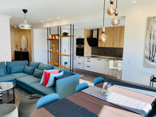 a living room with a blue couch and a table at Lovely apartment for family and group of friends in Póvoa de Santa Iria