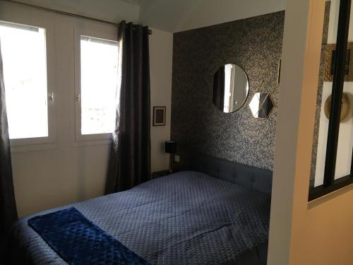 1 dormitorio con cama y espejo en la pared en Studio 15, en Honfleur