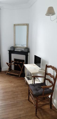 een kamer met een stoel en een bureau met een laptop bij La Joséphine in Cosne Cours sur Loire