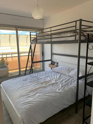 - une chambre avec 2 lits superposés et une vue sur la plage dans l'établissement Appartement vue sur mer courseulles, à Courseulles-sur-Mer