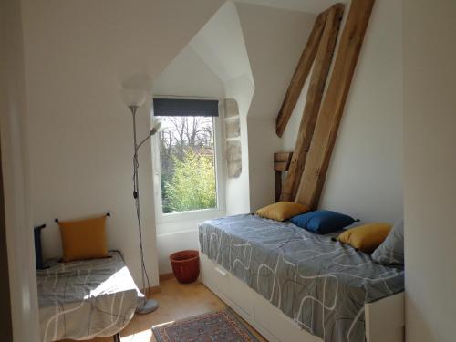 Huisseau-sur-CossonにあるGite du Colombier - Charme et Vieilles Pierresのベッドルーム1室(ベッド2台、窓付)
