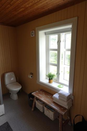 a bathroom with a toilet and a window at Lofoten Hiking Lodge in Bøstad