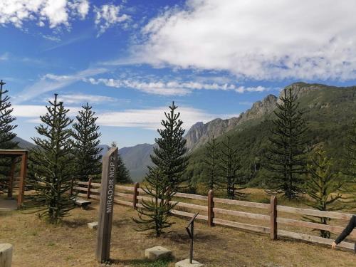a fence with trees and mountains in the background at Casa Bilbao Villarrica in Villarrica