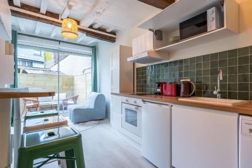 une cuisine avec des placards blancs et du carrelage vert dans l'établissement LES HORTILLONNAGES_B&B INN_Centre ville_Terrasse_Wifi_Netflix, à Amiens