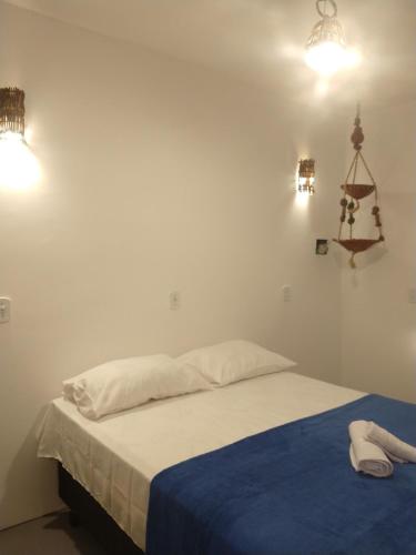 a bedroom with a bed with a blue blanket and lights at Al Mare_ BG in Barra Grande