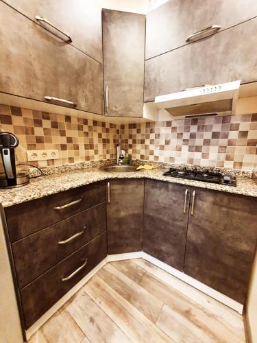 a kitchen with wooden cabinets and a counter top at Old Batumi in Batumi