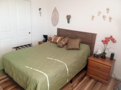 a bedroom with a bed with a green comforter at Room in Campbell with Own Bthrm in Campbell