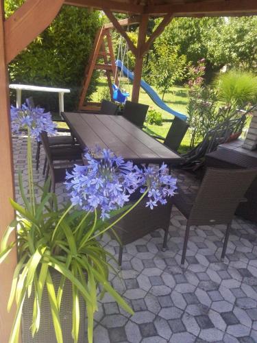 a table and chairs with purple flowers on a patio at Marietta Apartman in Hévíz
