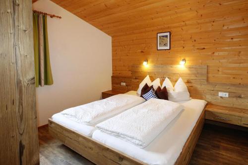 una camera con un grande letto in una parete di legno di Semi-detached house, Zell am Ziller a Zell am Ziller