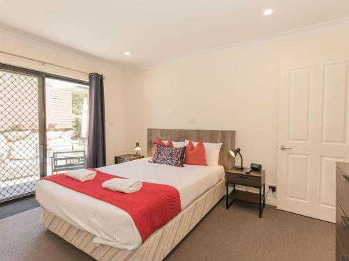 a bedroom with a large bed and a window at Jackson Hole 3 in Jindabyne