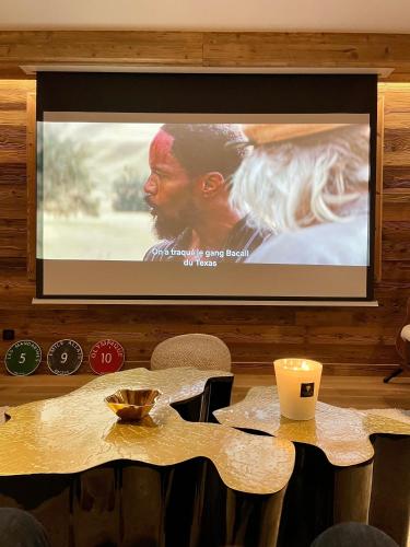 a projection screen on a wall with a table with chairs at Standing Megeve - 2 to 8 people - Mont d'Arbois in Megève