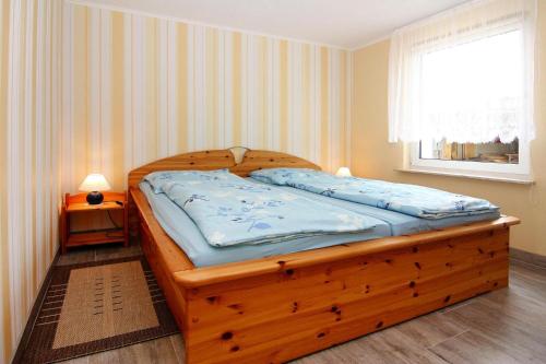 a wooden bed in a room with a window at Cottage, Karl Hagen in Ostseebad Karlshagen