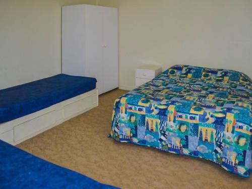 a bedroom with a bed and a blue comforter at 2 Rockpool Road in Tuncurry