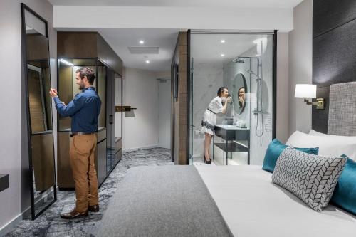 a man is standing in a hotel room at Crowne Plaza Christchurch by IHG in Christchurch