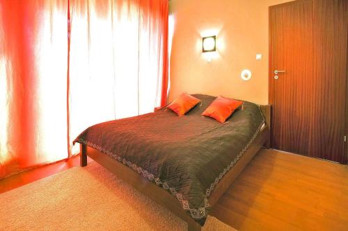 a bedroom with a bed with two orange pillows on it at Holiday flat, Swinoujscie in Świnoujście
