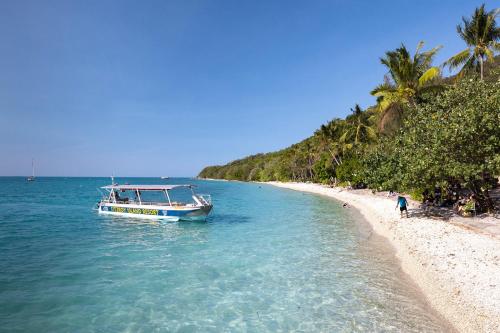 a boat in the water next to a beach at Fitzroy Island Resort in Fitzroy Island