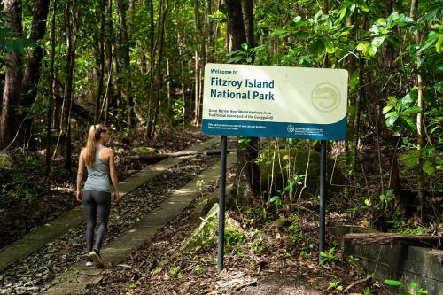 a woman walking on a trail next to a sign at Fitzroy Island Resort in Fitzroy Island
