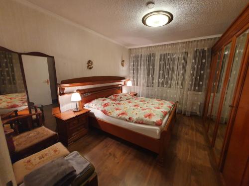 a bedroom with a bed and a mirror and a chair at Schönes Apartment mit Pool&Sauna in Bingen am Rhein