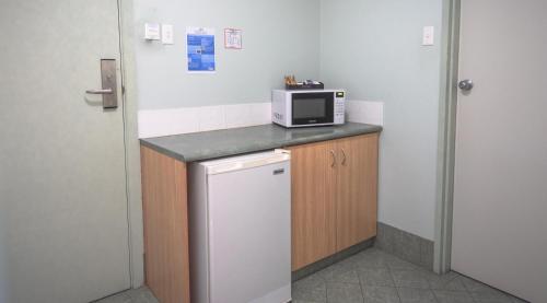 a kitchen with a microwave and a refrigerator at Heritage Resort Shark Bay in Denham