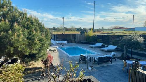 a backyard with a swimming pool and a patio with furniture at Rêves Étoilés in Setúbal