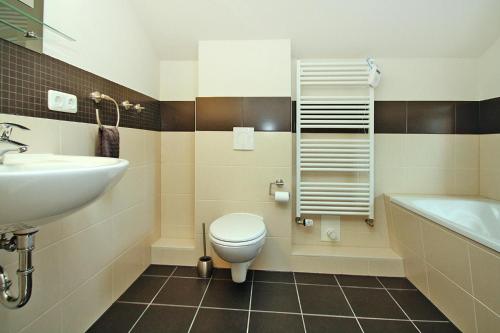 a bathroom with a toilet and a sink and a tub at Holiday home Min Kaat, Nakenstorf in Nakensdorf