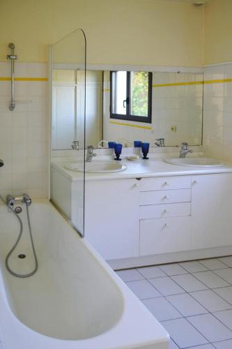 une salle de bain avec deux lavabos et une baignoire dans l'établissement Villa in Plougasnou with Stunning Sea Views, à Plougasnou