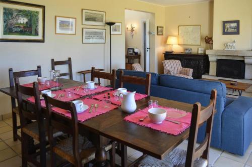 une salle à manger avec une table et un canapé bleu dans l'établissement Villa in Plougasnou with Stunning Sea Views, à Plougasnou