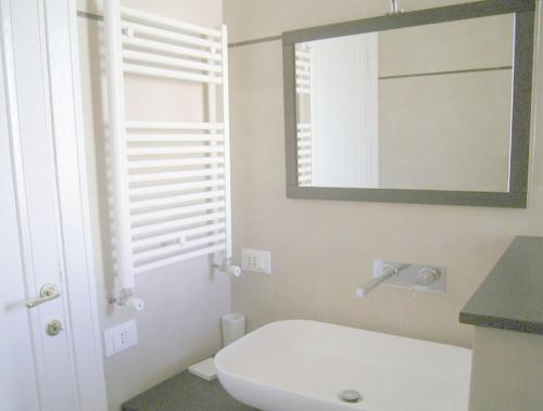 a bathroom with a white toilet and a mirror at Cathy Apartment in Rome