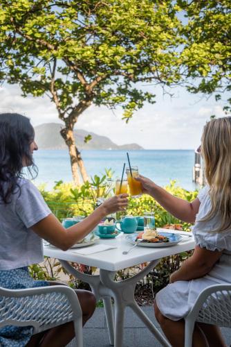 two women sitting at a table drinking orange juice at Fitzroy Island Resort in Fitzroy Island