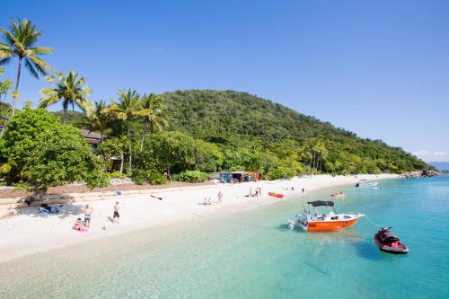a group of people on a beach with a boat at Fitzroy Island Resort in Fitzroy Island