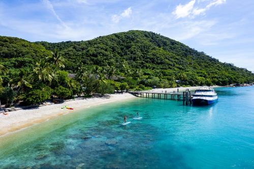 two people are in the water next to a boat at Fitzroy Island Resort in Fitzroy Island