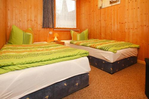 two beds in a room with wood paneling at Holiday home in Sewenkow with a terrace in Sewekow