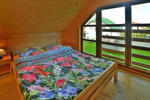 a bedroom with a bed in a room with windows at Terraced Houses, Grzybowo in Grzybowo