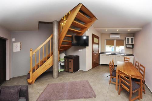 a living room with a staircase and a table and a kitchen at Comfortable holiday homes Jaroslawiec in Jarosławiec