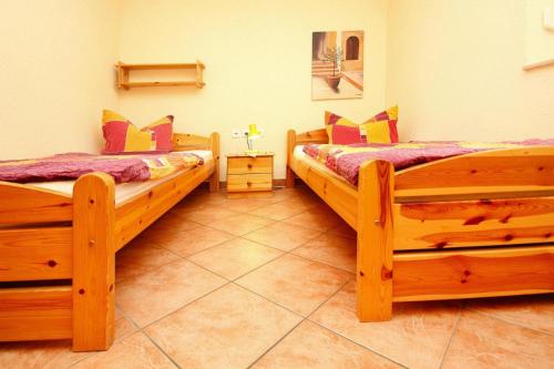 two wooden beds in a room with a tiled floor at Holiday house in Sewenkow with parking space in Sewekow