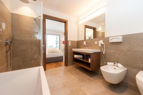 阿蓋特的住宿－Hotel Lambrechtshof，浴室配有盥洗盆、卫生间和浴缸。