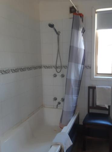 a bathroom with a shower with a shower curtain at Welcome Stranger Cottage in Maryborough