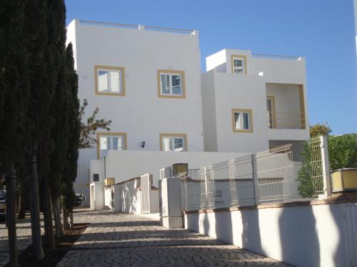 a white building with a fence in front of it at Vila Algarvia Boutique & Suites in Albufeira