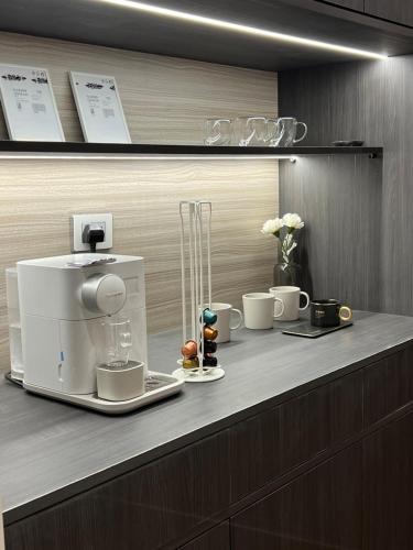 a counter with cups and a coffee maker on it at Family Luxury apartment at Milsa Nasr City , Building 27 in Cairo