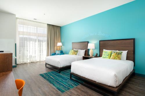 a hotel room with two beds and a blue wall at The Lodge at Camp Margaritaville in Pigeon Forge