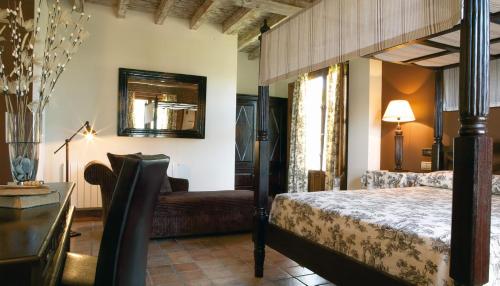 アルヌエロにあるHotel Posada La Robledaのベッドルーム1室(ベッド1台、ソファ、テーブル付)