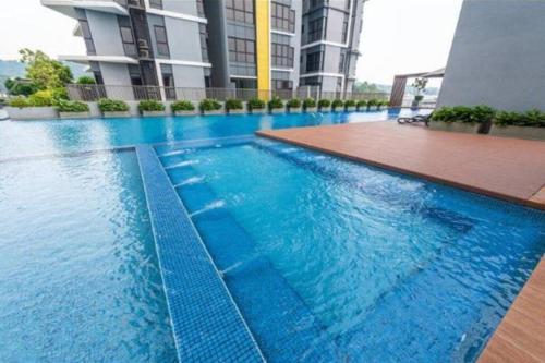 a large swimming pool with blue water in a building at Cozy Mayfair Homestay in Puchong