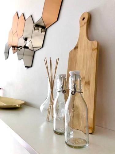 three glass bottles on a counter with a cutting board at Cozy Mayfair Homestay in Puchong