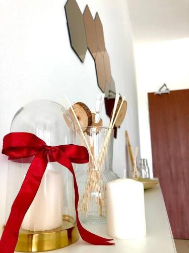 a glass vase with a red ribbon on a counter at Cozy Mayfair Homestay in Puchong