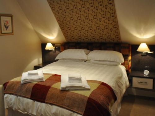 1 dormitorio con 1 cama grande y toallas. en Canford Crossing, en Wimborne Minster