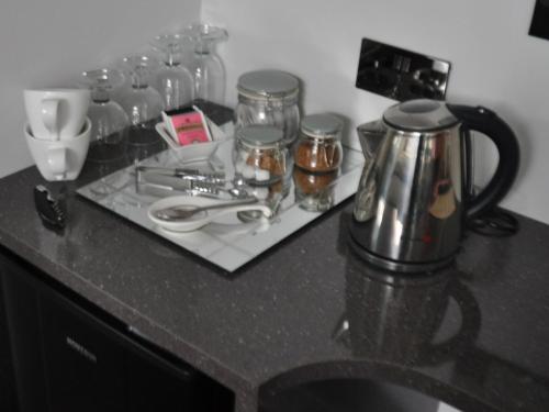 a counter with a tea kettle and glasses on it at Canford Crossing in Wimborne Minster