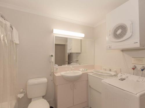 Un baño blanco con lavabo e inodoro. en Horizons 505/10 Kosciuszko Road, en Jindabyne