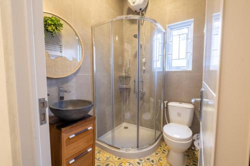 a bathroom with a shower and a toilet and a sink at Villa Siji Gempol in Yogyakarta